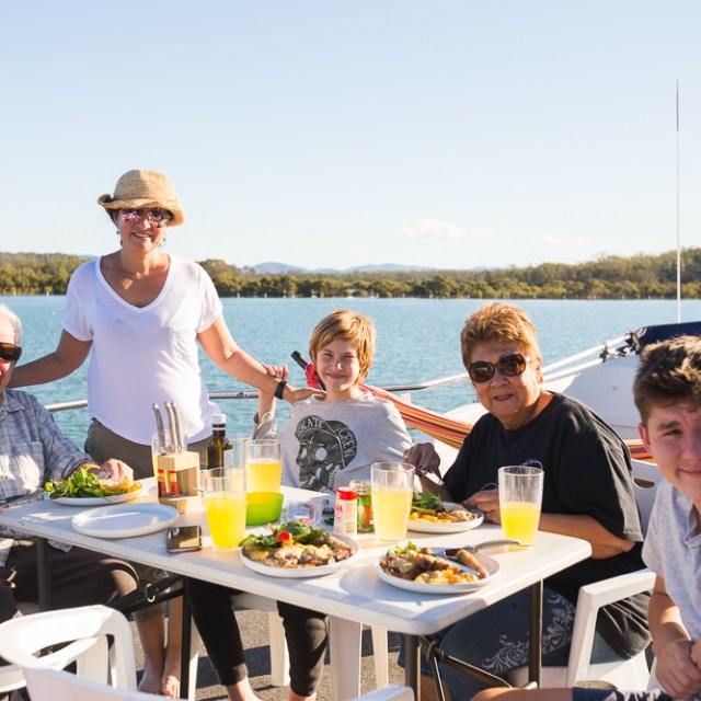family vacation enjoying eating dinner on the rented houseboat book today Forster NSW